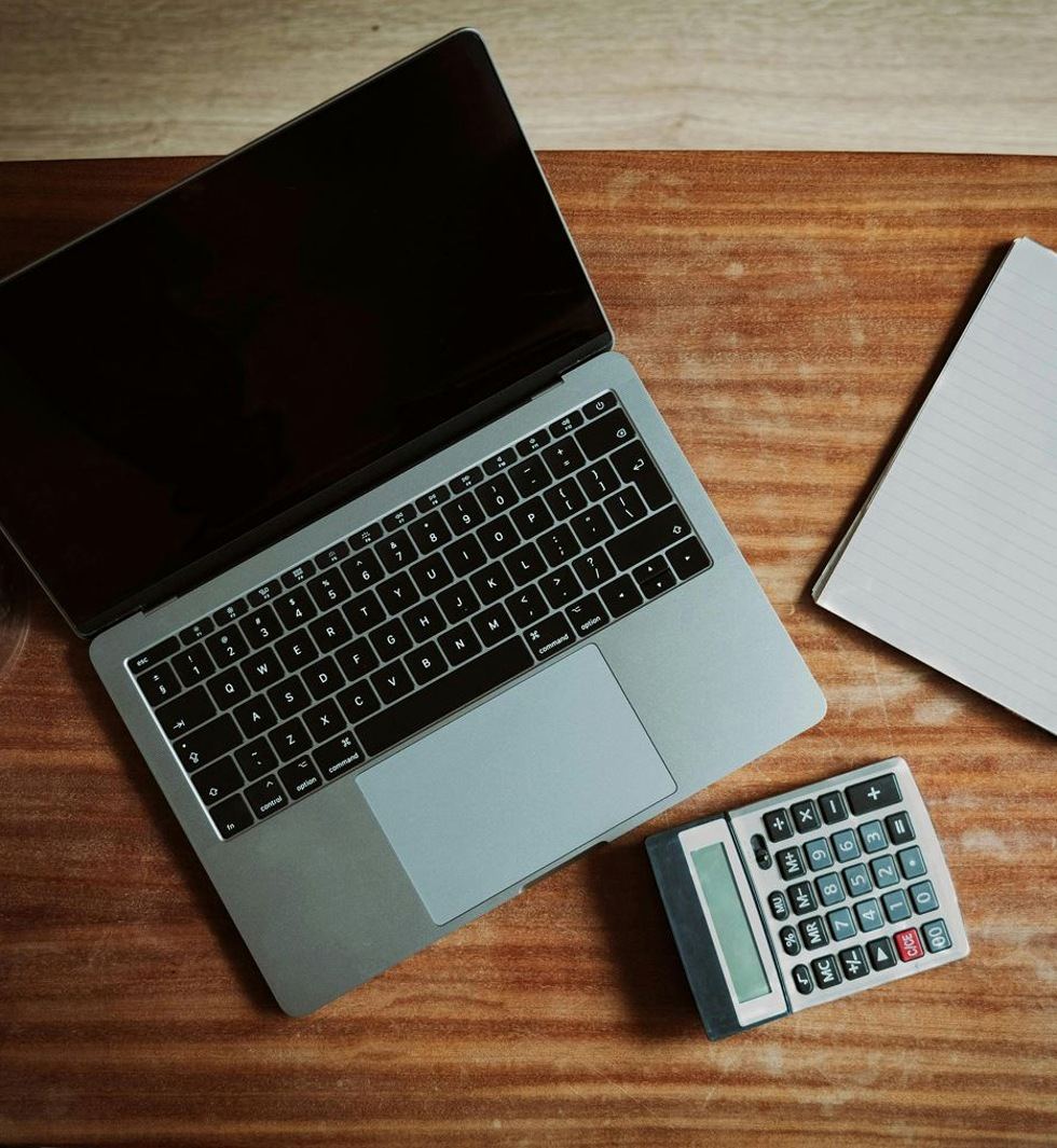 Bookkeeping workspace with laptop, calculator and notebook
